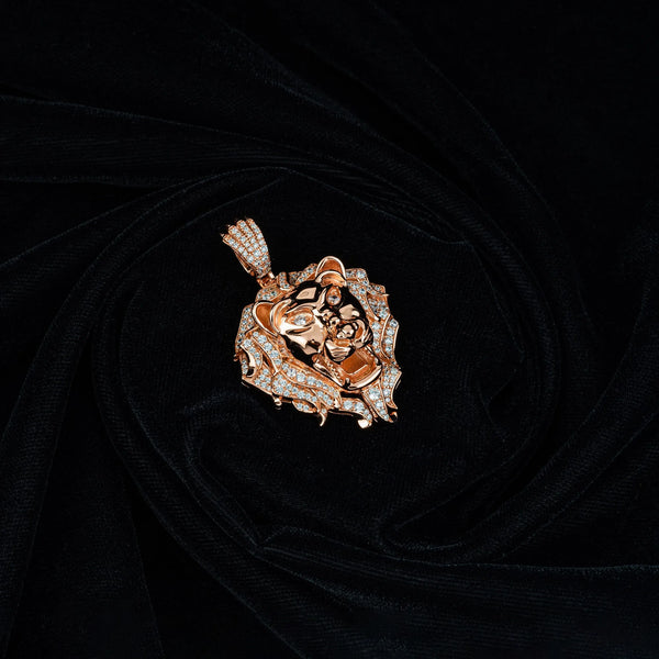 A Majestic Roar Zircon Studded Rose Gold Locket from Touch 925 lies on a smooth, black fabric background. The intricate detailing of the lion's mane and facial features makes the locket eye-catching and luxurious.